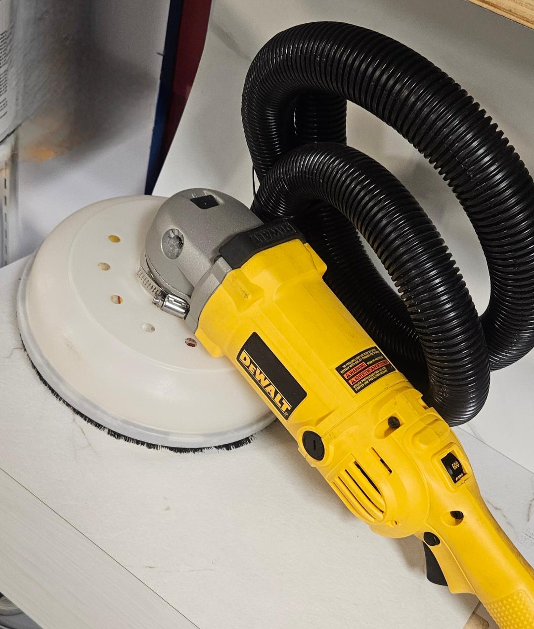 Close up detail of the KS100 vacuum outlet and hose connection on a DeWalt power tool